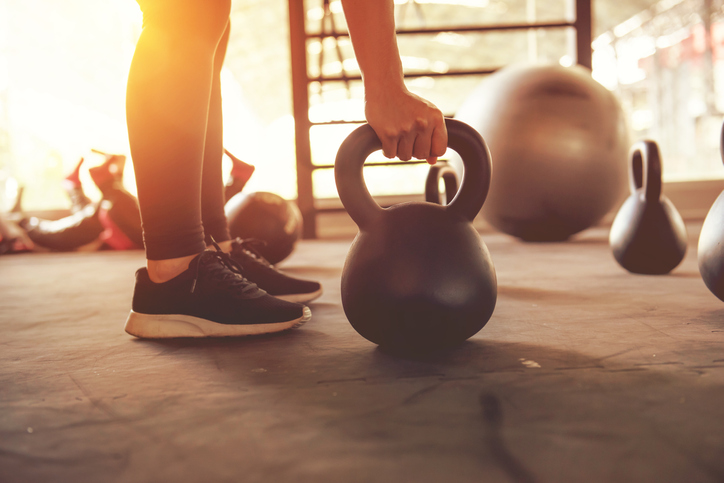 Fitness training with kettlebell in sport gym.